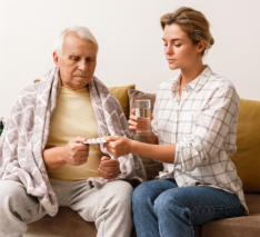 caregiver giving medications to senior