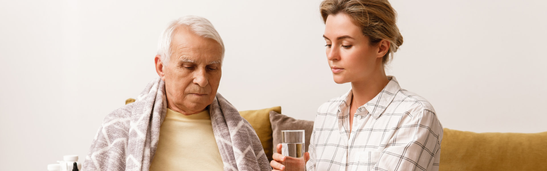 caregiver giving medication to senior